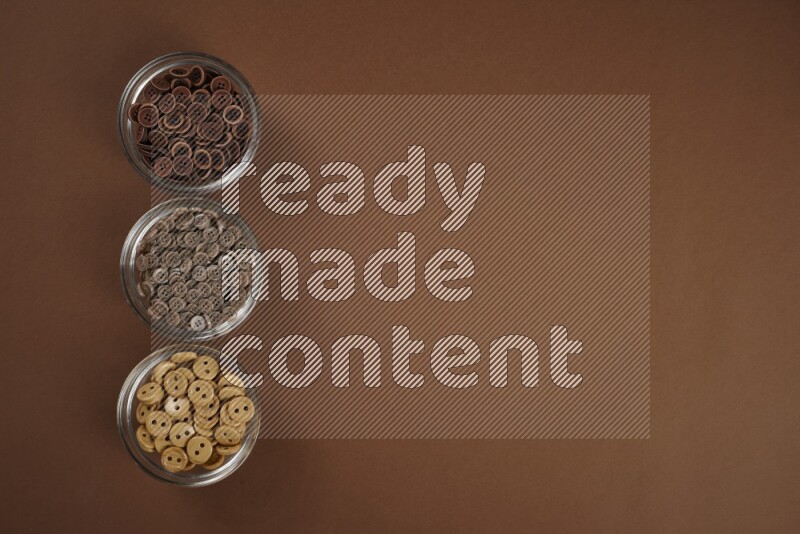 مجموعة من أدوات الخياطة والتفصيل بنية اللون على خلفية بنية