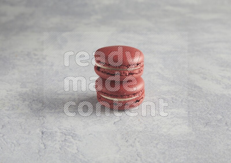 45º Shot of two Red Velvet macarons  on white  marble background