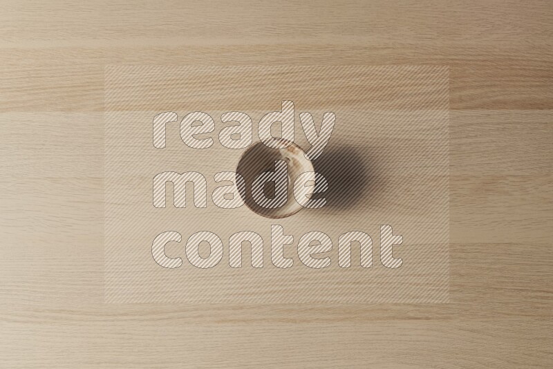 A beige pottery bowl on light wooden background