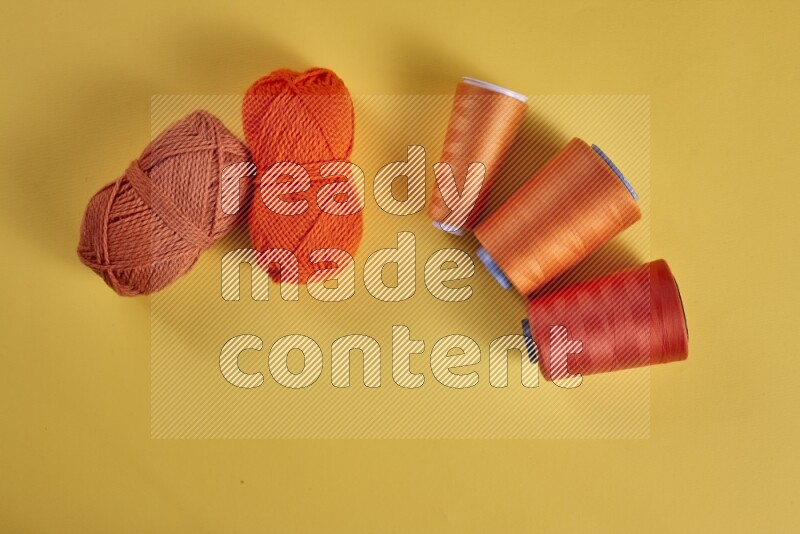 مجموعة من أدوات الخياطة والتفصيل برتقالية اللون على خلفية صفراء