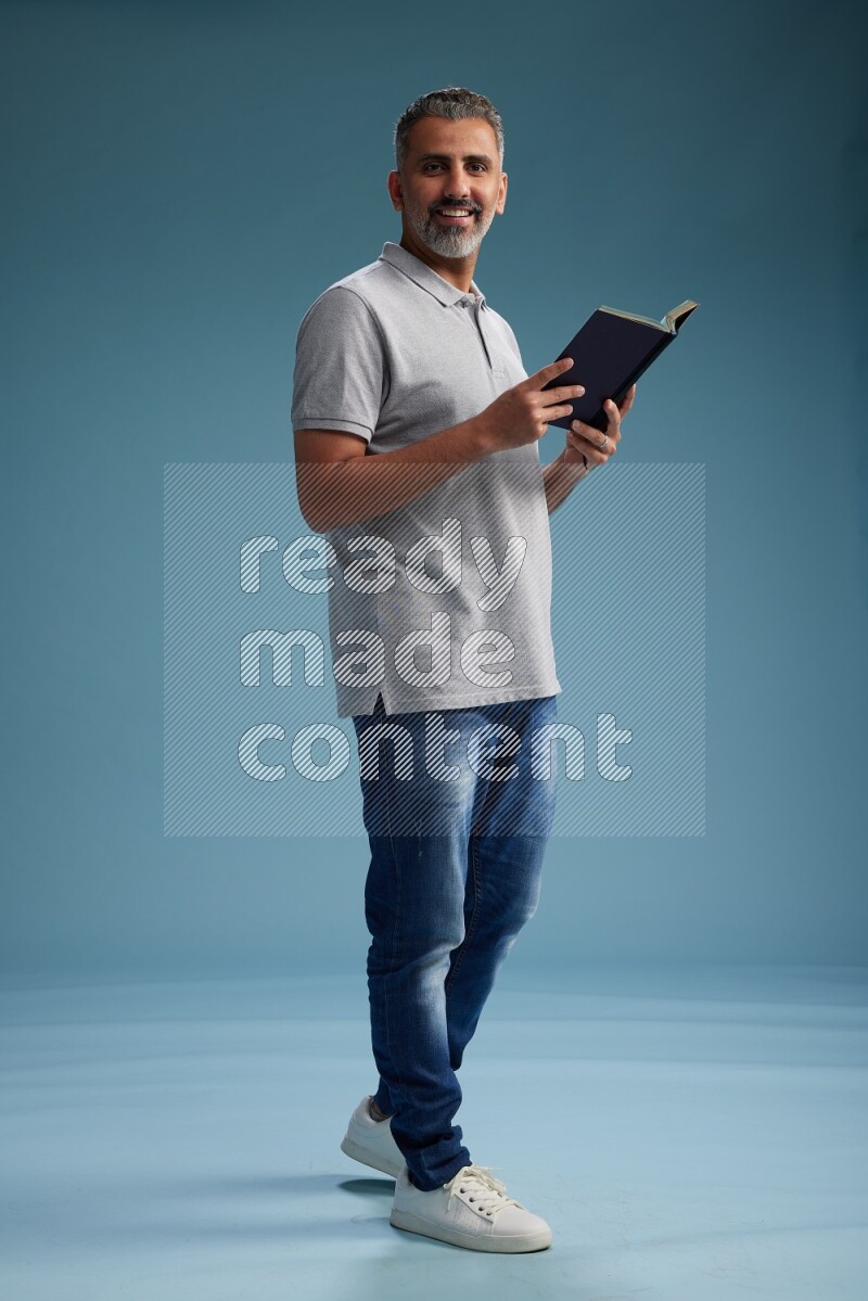 Man Standing reading book on blue background