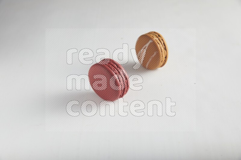 45º Shot of of two assorted Brown Irish Cream, and Red Velvet macarons on white background