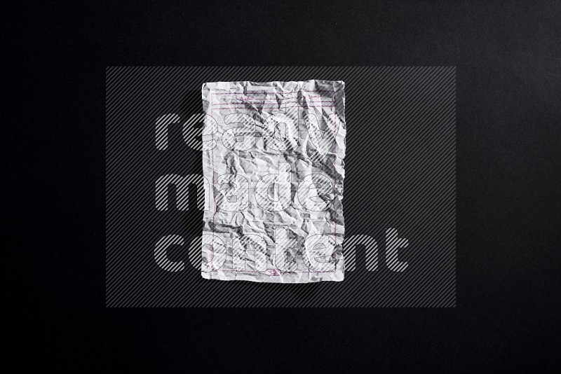 Crumpled notebook sheet on black background