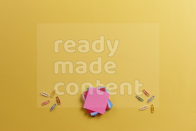 ورق ملاحظات متعدد الألوان مع مستلزمات مدرسية على خلفية صفراء