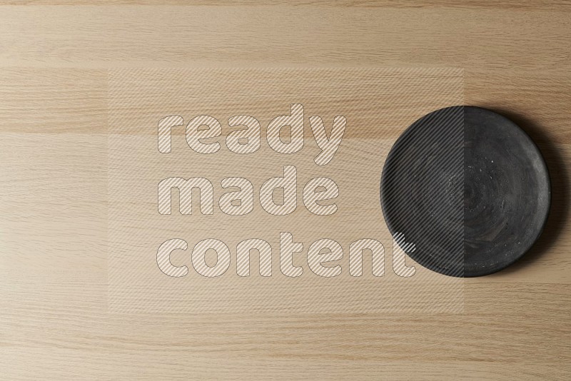 Top View Shot Of A Black Pottery Circular Plate on Oak Wooden Flooring