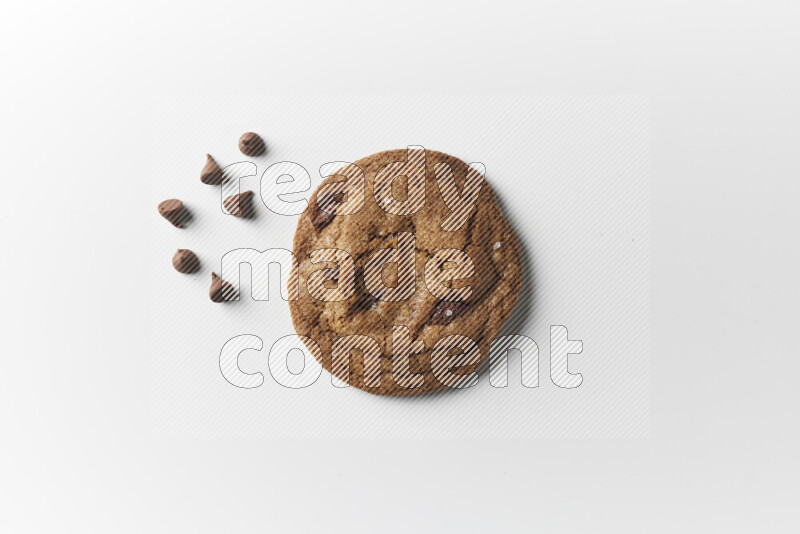 A single chocolate chips cookie with chocolate beside it on a white background