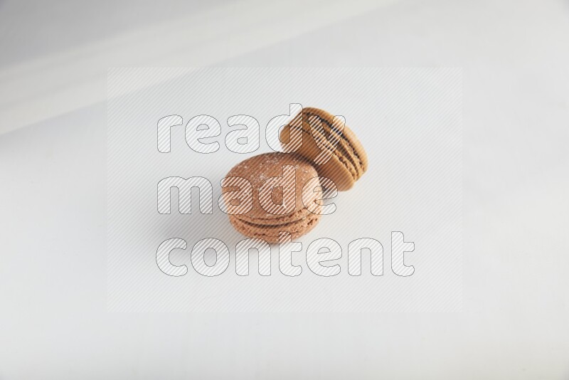 45º Shot of of two assorted Brown Irish Cream, and Brown Hazelnuts macarons on white background