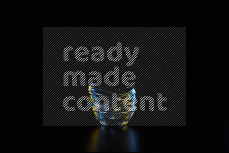 Glassware with rim light in blue and yellow against black background