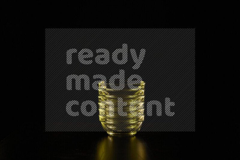 Glassware with rim light in yellow against black background