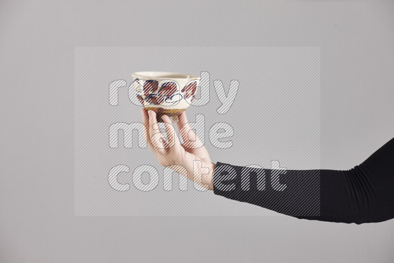 A woman in black abaya holding different pottery essentials in different positions