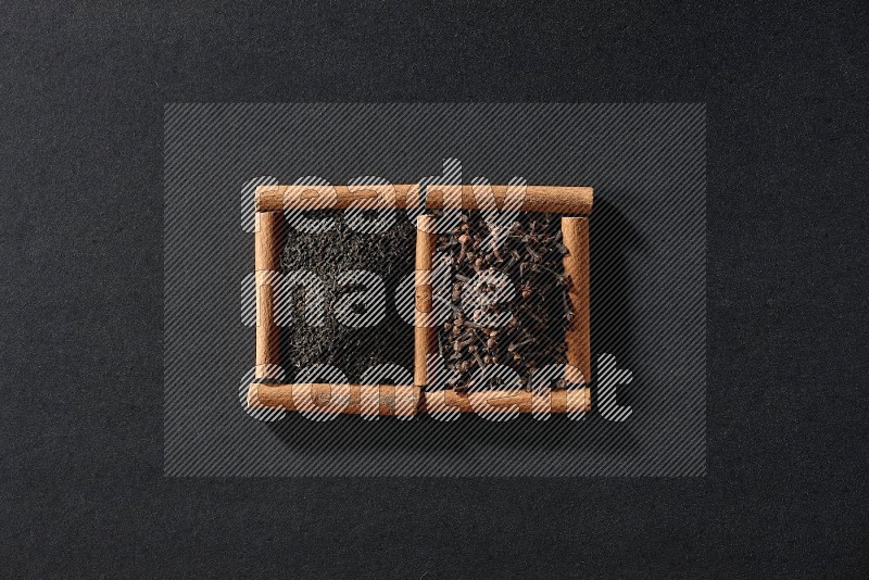 2 squares of cinnamon sticks full of tea and cloves on black flooring