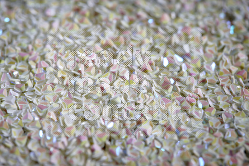 قطع صغيرة بلاستيكية ملونة للزينة متناثرة على خلفية سوداء