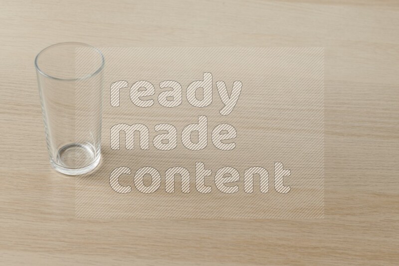 An empty glass cup on light wooden background