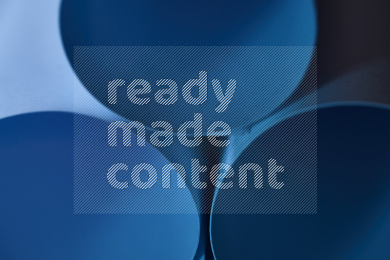 الصورة تعرض فن ورقي تجريدي بأشكال دائرية بدرجات متنوعة من اللون الأزرق