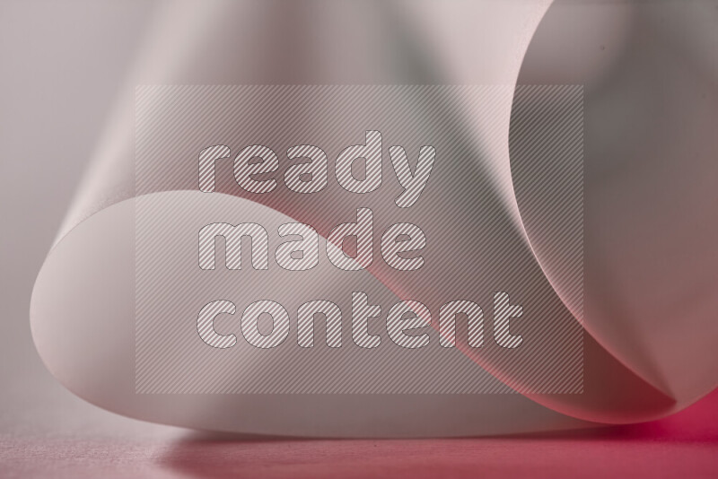 An abstract art piece displaying smooth curves in red and grey gradients created by colored light