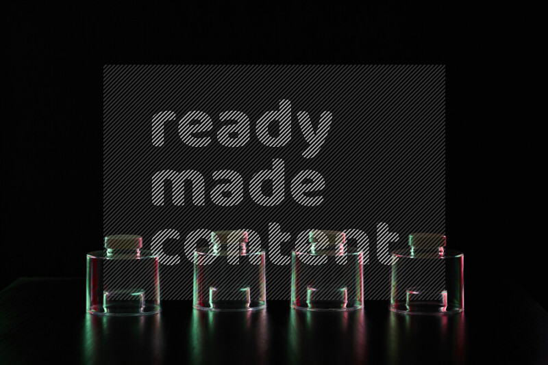 Glassware with rim light in red and green against black background