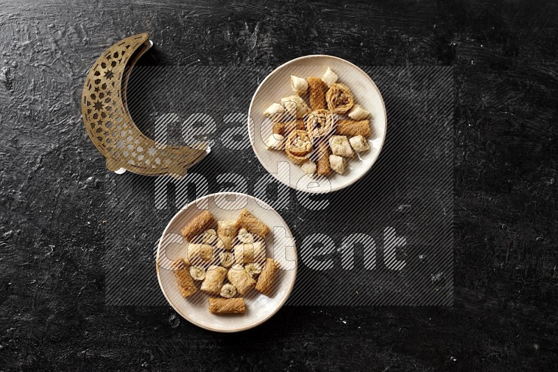 حلويات شرقية في أطباق فخارية مع فانوس خشبي علي خلفية خشبية