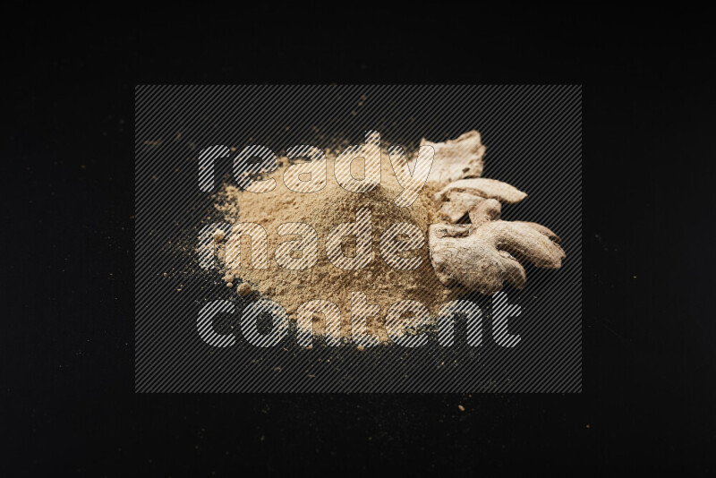 A bunch of ground ginger powder on black background