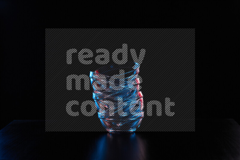 Glassware with rim light in red and blue against black background