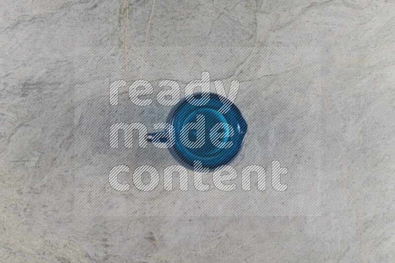 A colored glass jug on grey marble background