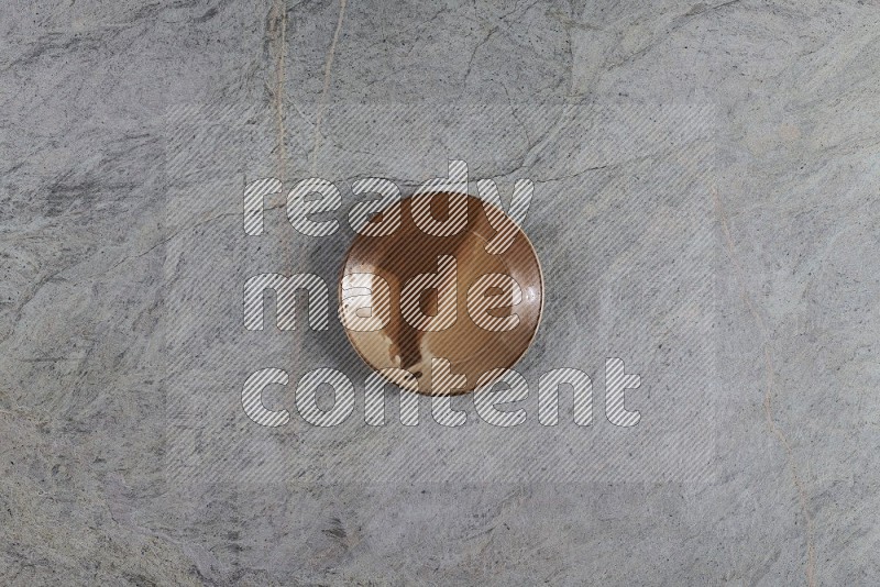 Top View Shot Of A Multicolored Pottery Plate On Grey Marble Flooring