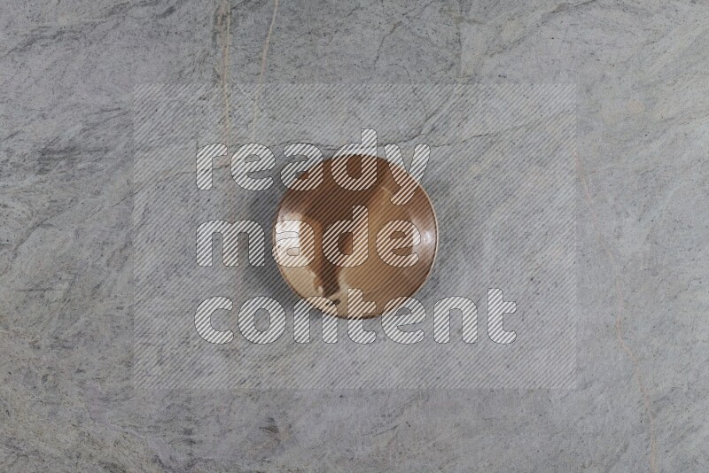 A multicolored pottery plate on grey marble background