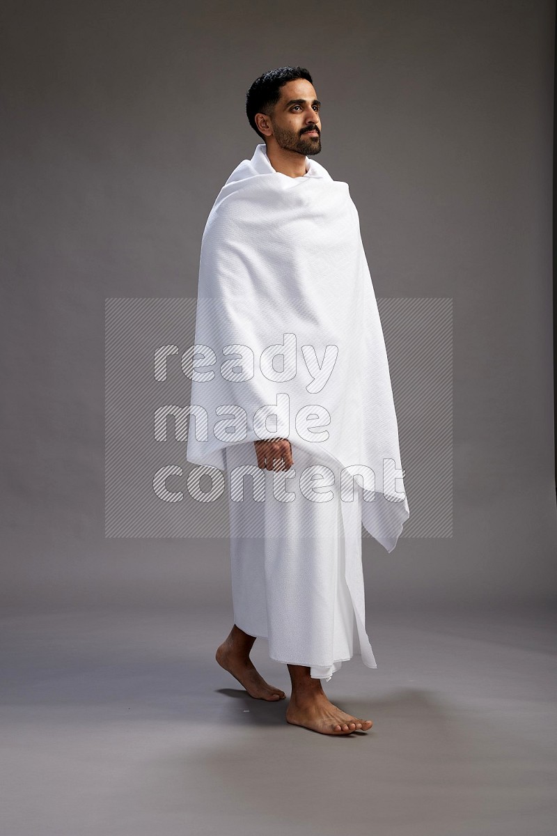 A man wearing Ehram Standing Interacting with the camera on gray background