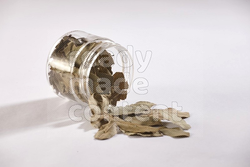 A glass jar full of laurel bay and jar is flipped and leaves spread out on white flooring in different angles