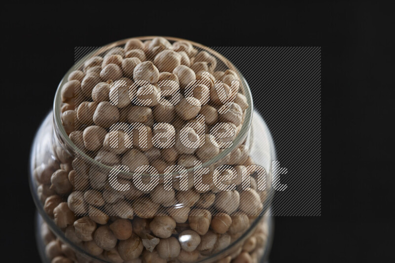 Chickpeas in a glass jar on black background