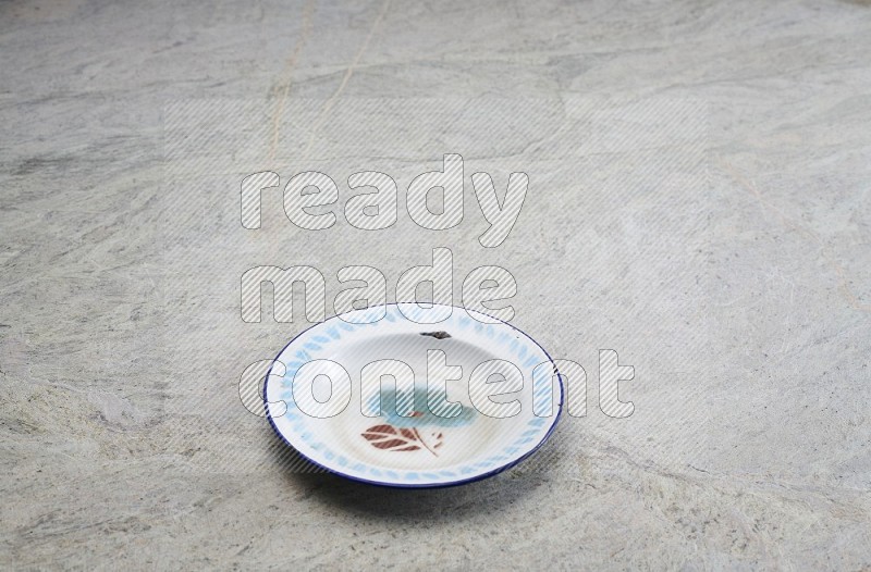 A Vintage Metal Plate On Grey Marble Flooring