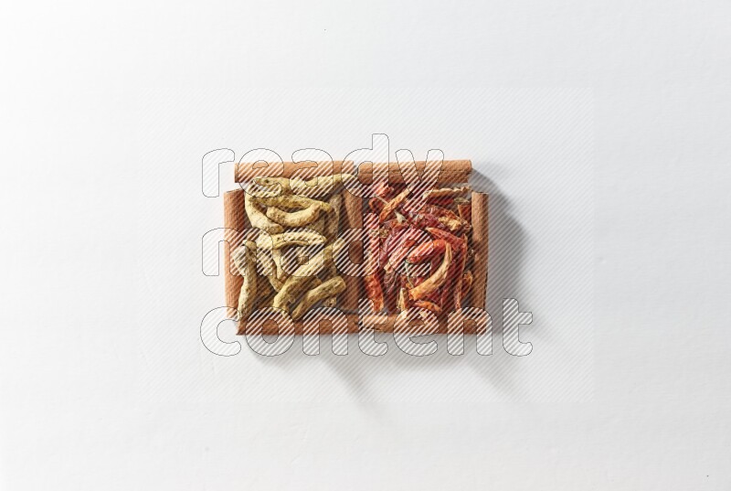 2 squares of cinnamon sticks full of dried red chilis and turmeric fingers on white flooring