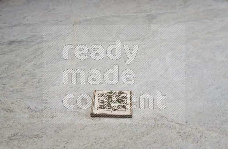 Top view shot of a pottery coaster\ tile on beige marble flooring