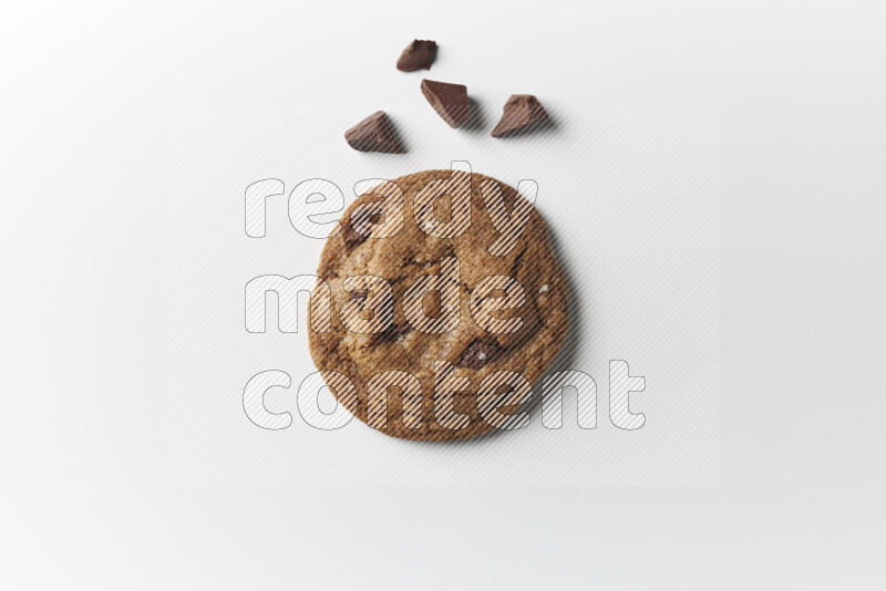 A single chocolate chips cookie with chocolate beside it on a white background