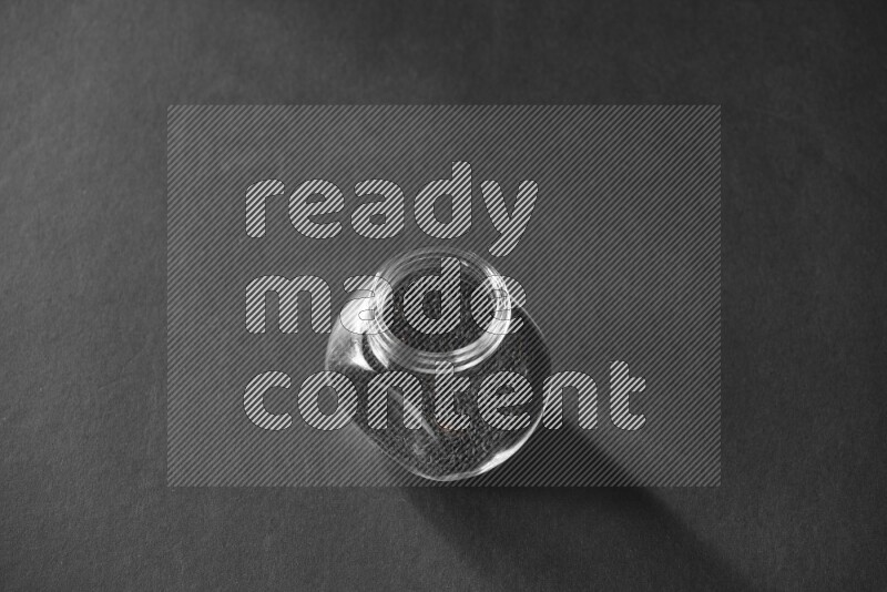 حبة البركة في وعاء زجاجي علي خلفية سوداء