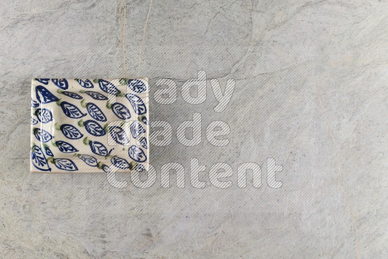 Top View Shot Of A Decorative Pottery Plate On Grey Marble Flooring