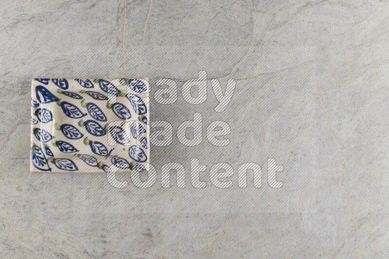 A decorative pottery plate on grey marble background