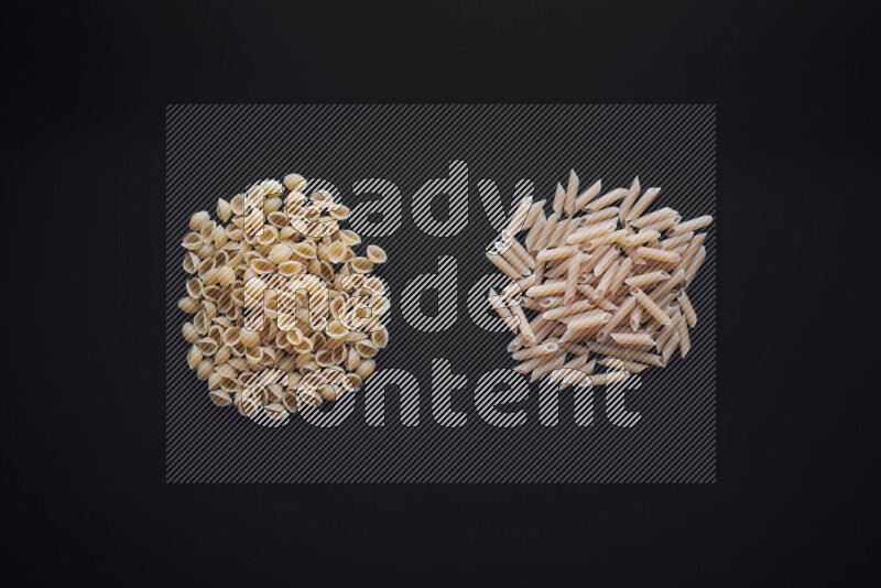 Different pasta types in bunches on black background