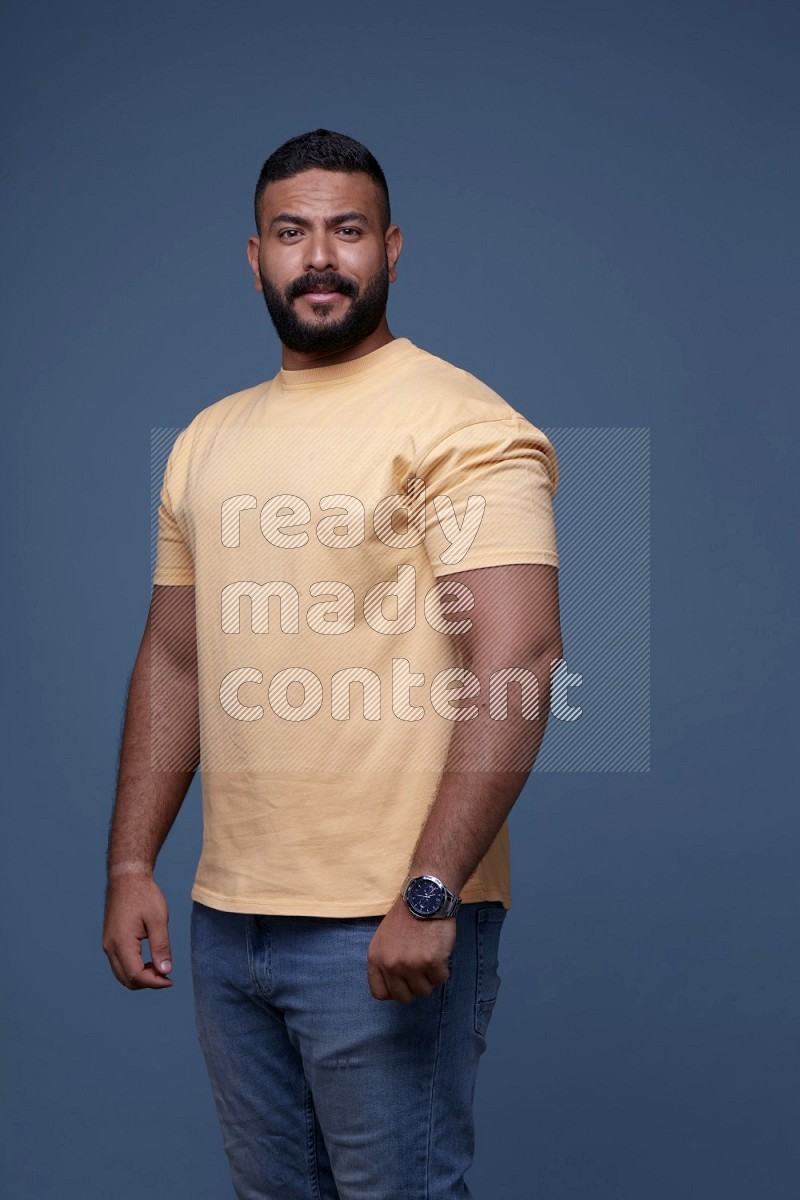 رجل يرتدي قميص اصفر بأكمام قصيرة وبنطال جينز ازرق يقف بأوضاع مختلفة