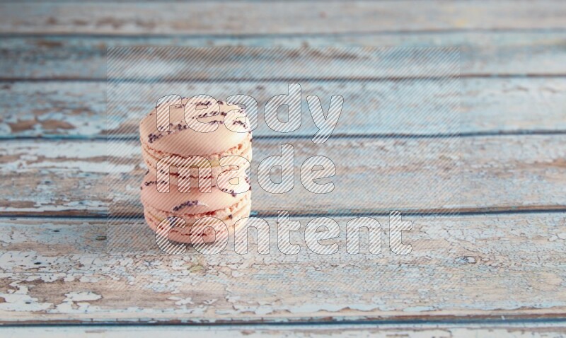 45º Shot of two pink orange blossom macarons on light blue wooden background