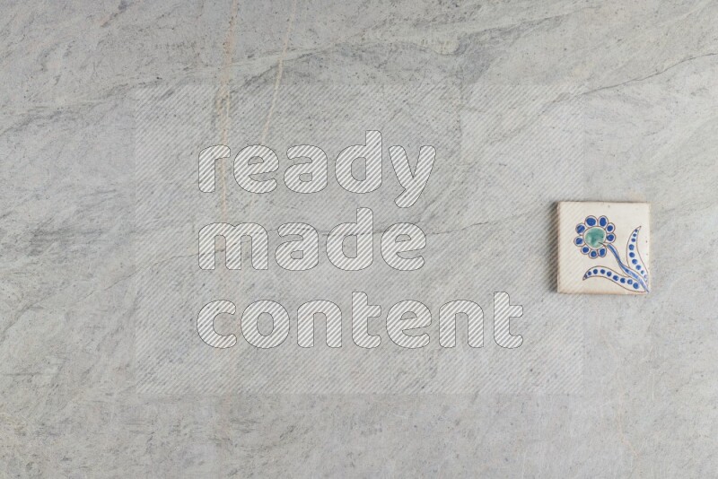 A decorative pottery coaster on grey marble background