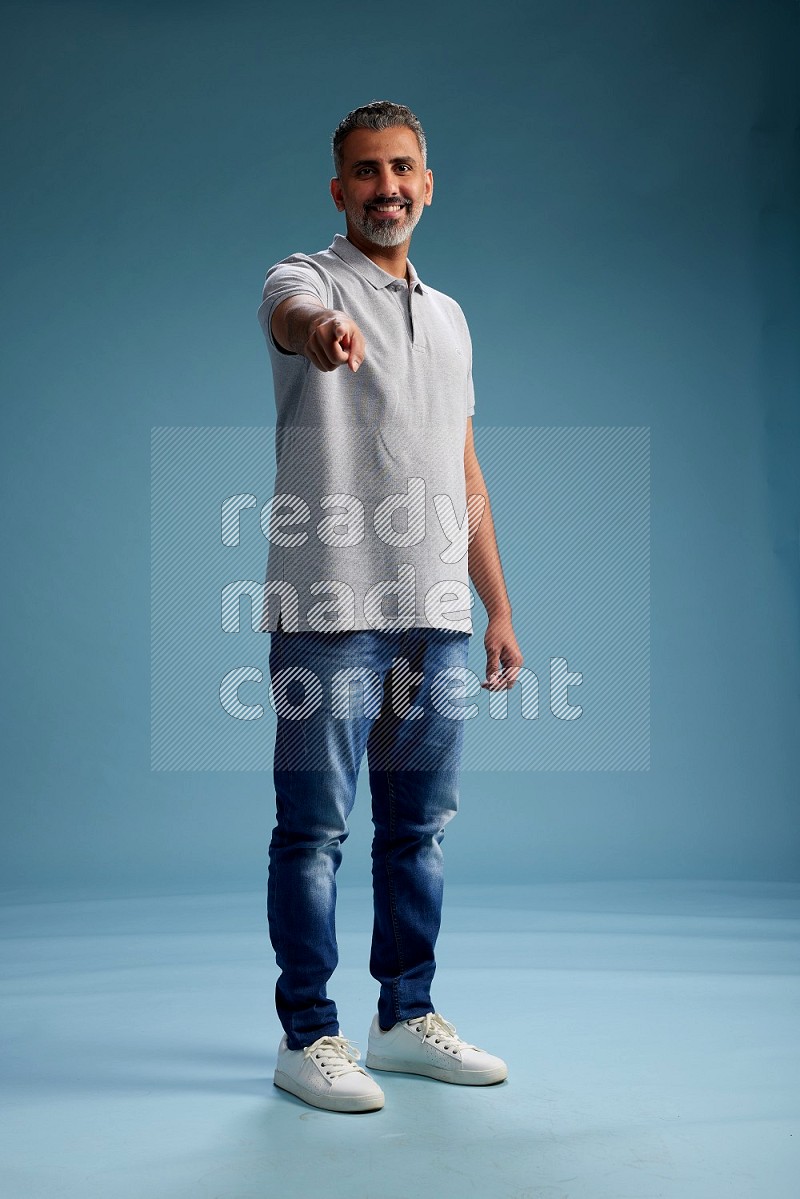 Man Standing Interacting with the camera on blue background