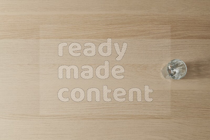 An empty glass cup on light wooden background