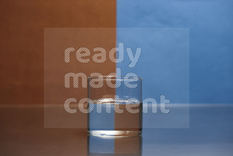 The image features a clear glassware filled with water, set against brown and blue background