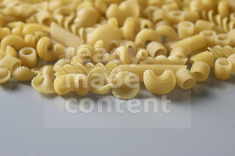 Different pasta types on light blue background