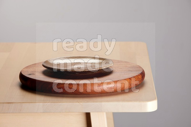 multi-colored pottery Plate placed on a dark colored wooden tray on the edge of wooden table