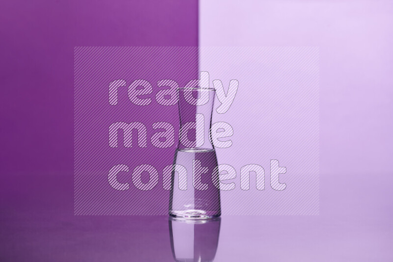 The image features a clear glassware filled with water, set against purple and light purple background