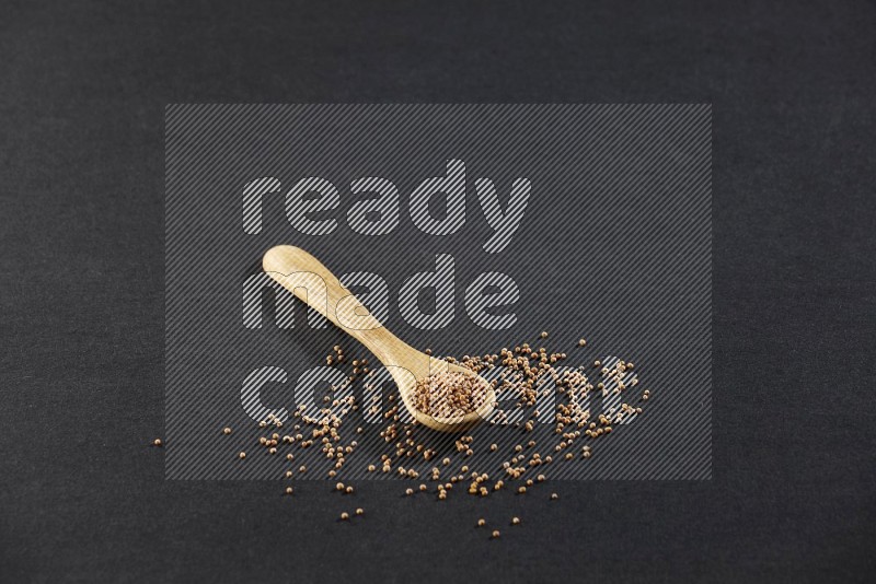A wooden spoon full of mustard seeds on a black flooring in different angles