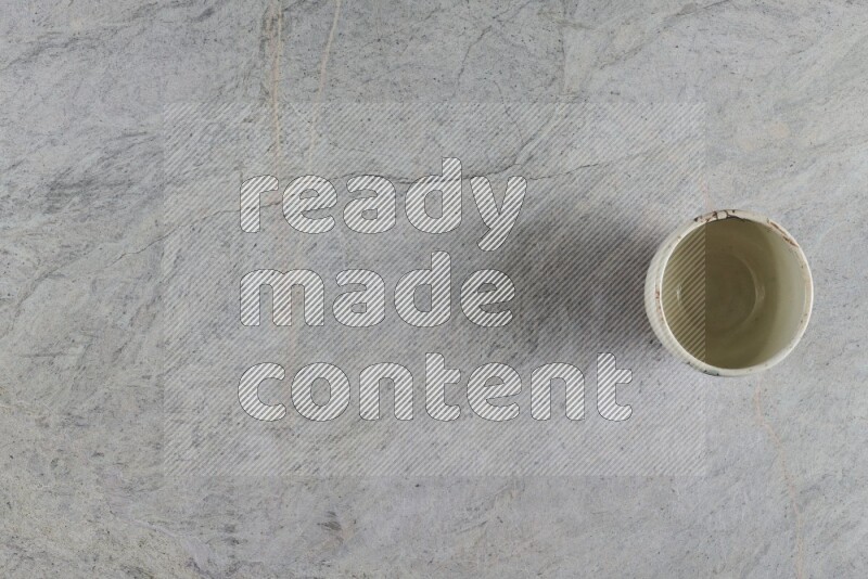 A multicolored pottery Cup on grey marble background