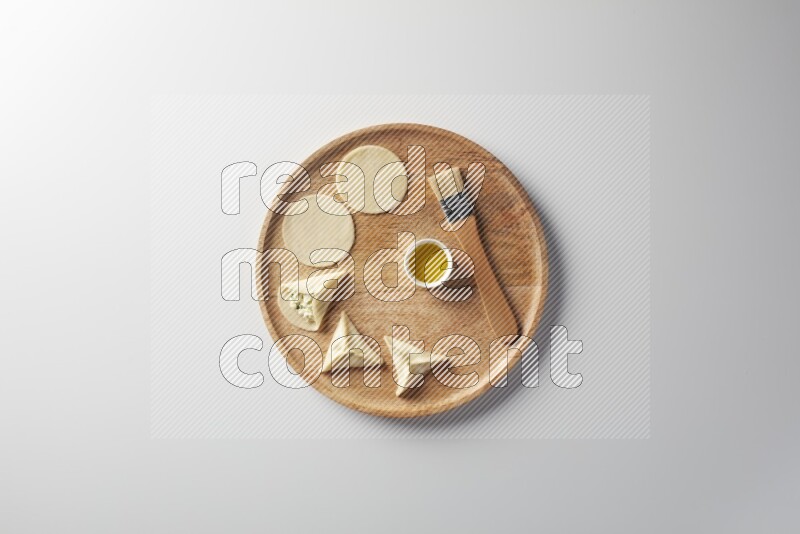 two closed sambosas and one open sambosa filled with cheese while oil with oil brush aside in a wooden dish on a white background
