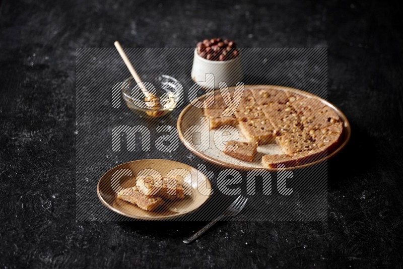 Basbousa with nuts and honey in a dark setup